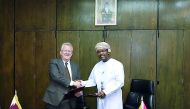 Michael Ryan, Chief Executive Officer of the QFC Regulatory Authority (left), and Taher Salim Al Amri, Executive President of the Central Bank of Oman, exchanging documents after the signing ceremony.