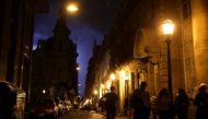 People walk on a street as lightning illuminates the sky in Buenos Aires, Argentina, October 18, 2017. Reuters/Marcos Brindicci