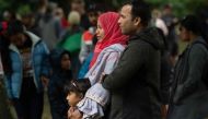 A Muslim family stands across the road from the Dean Street mosque when worshipers were gunned down in Christchurch on March 17, 2019, two days after a shooting incident at two mosques in the city.  AFP / Marty Melville
