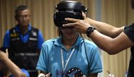 A Thai forensic police officer wearing a virtual reality headset before searching for victims in a simulated city in ruins at the police headquarters in Chon Buri province on February 26, 2019. AFP / Lillian Suwanrumpha 