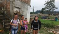 Landslide survivor Eugenia Torres (left) and her friends stand behind a home in a flood prone area in Mocoa,Colombia. March 28, 2019. Thomson Reuters Foundation /Anastasia Moloney