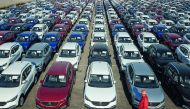 A staff member walks past new cars waiting to be exported at a port in Lianyungang in China's eastern Jiangsu province on March 31, 2019. AFP