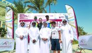 The podium winners at the Qatari Diar Triathlon pose for a picture with officials of Qatar Cycling and Triathlon Federation at  Lusail City. 