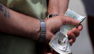 REPRESENTATIONAL IMAGE: A man holds various English Pound notes as he waits in line to exchange it for Euros notes outside a money exchange office in the British overseas territory of Gibraltar, June 24, 2016. (AFP) 