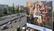 Indian commuters pass a poster advertising 'Facebook Live: What You Love' campaign in Bangalore on March 22, 2018. AFP/Manjunath Kiran