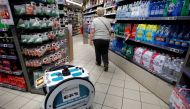 A woman does her shopping at a store using an autonomous robot, shaped and inspired by Star Wars R2D2, in a test for the delivery of groceries by Franprix supermarket chain in the 13th district of Paris, France, April 17, 2019. REUTERS/Charles Platiau
