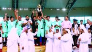 The players and officials of Ibn Taymiyyah Independent Secondary School celebrate with the trophy as officials applaud them after the final at Aspire Dome, yesterday. 