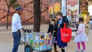 A woman buys ice cream from a vendor outside the California Science Center at Exposition Park in Los Angeles on March 24, 2019.  AFP / Agustin Paullier 