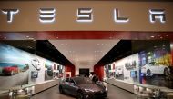 In this file photo taken on February 19, 2014 people look at a Tesla Motors vehicle on the showroom floor at the Dadeland Mall in Miami. AFP/Getty Images North America/Joe Raedle