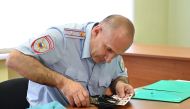 An official of a migration department under Russia's Interior Ministry works on photographs while registering passport applications of Ukrainian separatist-controlled Donetsk and Luhansk Regions' residents, after Russia's President Vladimir Putin signed a