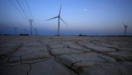 Cracked earth marks a dried-up area near a wind turbine used to generate electricity at a wind farm in Guazhou, 950km (590 miles) northwest of Lanzhou, Gansu Province September 15, 2013. Reuters/Carlos Barria