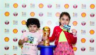 Young football fans pose for a photograph with the Amir Cup Trophy at the Qatar Shell Booth at Doha Festival City. 