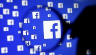 FILE PHOTO: A man poses with a magnifier in front of a Facebook logo on display in this illustration taken in Sarajevo, Bosnia and Herzegovina, December 16, 2015. REUTERS/Dado Ruvic/Illustration