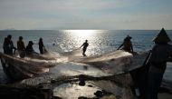 Fishermen carry their fishing nets along the shore in Banda Aceh on May 24, 2019. AFP / Chaideer Mahyuddin 