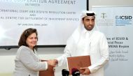 Faisal Rashid Al Sahouti (right), CEO, Qatar International Court and Dispute Resolution Centre (QICDRC); and Meg Kinnear, Secretary General, International Centre for Settlement of Investment Disputes (ICSID), exchanging documents after they signed an agre