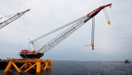 A crane hangs over the first jacket installed to support a turbine for a wind farm in the waters of the Atlantic Ocean off Block Island, Rhode Island July 27, 2015.  Reuters/Brian Snyder