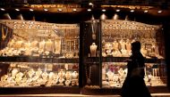 A woman walks past gold jewellery displayed in a shop window at the Gold Souq in Dubai, March 24, 2018. Reuters/Christopher Pike