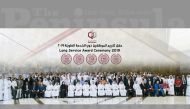 Qatargas officials and the long-serving employees posing for a group picture.