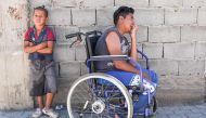 A scene in which one Jetullah Veliu, a 16-years-old, sitting on a wheelchair along a street in the Roma neighborhood in the town of Mitrovica on July 7, 2017. AFP/Armend Nimani