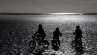 Children ride their bike along the beach during low tide near St Helier, Jersey, November 11, 2012. Reuters/Stefan Wermuth
