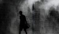 A man walks past a public water spray on the bank of the Seine river in Paris on July 25, 2019 as a new heatwave hits Europe. (AFP / Philippe LOPEZ)