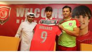 Iraqi star Mohanad Ali (centre) holding an Al Duhail jersey with coach Rui Faria and a club official during a press conference in Doha, yesterday.