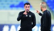 Al Sadd’s coach Xavi Hernandez  speaks with a club official during a training session.