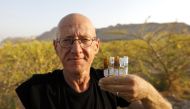 Israeli farmer Guy Erlich shows ampules of scented oils that he extracted from plants and trees at a farm on a small hill near the settlement of Almog in the Israeli-occupied West Bank, on May 28, 2019. AFP / Menahem Kahana
 