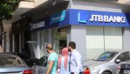 People walk past a branch of Jammal Trust Bank in the Beirut's Hamra street on August 30, 2019, in the Lebanese capital. AFP / Anwar Amro 