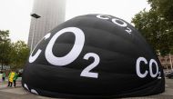Greenpeace activists inflate a giant balloon reading 