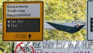 Demonstrators from the action group Sand im Getriebe (grit in the gears) calling for radical change in transport policy and in the motor industry have fixed a hammock and a banner reading 