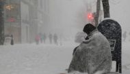 A homeless man asks for money outside a donut shop during white-out blizzard-like conditions in a winter snow storm in Boston, February 9, 2017. Reuters/Brian Snyder