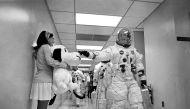 Apollo 10 Commander Tom Stafford, heading to the Kennedy Space Center launch pad, pats the nose of a stuffed Snoopy held by Jamye Flowers, the secretary of astronaut Gordon Cooper, May 18, 1969. NASA/AFP