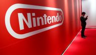 FILE PHOTO: A man stands in front of Nintendo's logo at the presentation ceremony of its new game console Switch in Tokyo, Japan, Jan. 13, 2017. REUTERS/Kim Kyung-Hoon/File Photo