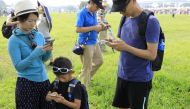 Visitors play Pokemon Go on their phones during the opening day of the Pokemon Go Safari Zone at the New Taipei Metropolitan Park in New Taipei City on October 3, 2019. / AFP / Daniel Shih