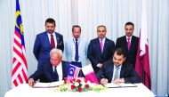 H E Ali bin Ahmed Al Kuwari (standing second right), Minister of Commerce and Industry, and other officials during the signing ceremony in Kuala Lumpur, Malaysia.