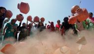  Women throw earthen pitchers onto the ground in protest against a shortage of drinking water outside the municipal corporation office in Ahmedabad, India, May 16, 2019. Reuters/Amit Dave 