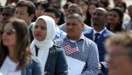 Immigrants look on before being sworn in as American citizens during a naturalization ceremony on the flight deck of the USS Hornet on July 3, 2018 in Alameda, California. Justin Sullivan / Getty Images / AFP