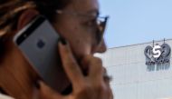 In this file photo taken on August 28, 2016 an Israeli woman uses her iPhone in front of the building housing the Israeli NSO group, in Herzliya, near Tel Aviv. AFP / Jack Guez
 