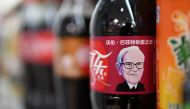 A Cherry Coke bottle featuring an image of US investor Warren Buffet is seen on a shelf at a convenience store in Beijing on April 5, 2017 .AFP / Greg Baker