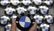 An employee holds a BMW logo on the production line of the BMW C evolution electric maxi-scooter at the BMW Berlin motorcycle plant, February 23, 2015. Reuters / Fabrizio Bensch