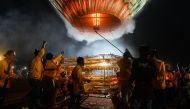 This picture taken on November 4, 2019 shows participants releasing a hot-air balloon attached with fireworks during the Tazaungdaing Lighting Festival at Taunggyi in Myanmar's northeastern Shan State. AFP / Ye Aung Thu
 