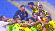 Qatar SC coach Wesam Rizik (in black) celebrates with his players after a win over Al Sadd at QSL.