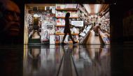 A museum employe walks past a large photograph of a manga store in Japan during a press preview for the exhibition Manga at the British Museum in London on May 22, 2019. AFP / Daniel Leal-Olivas