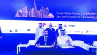  Qatar Chamber Board Member Dr Mohamed Jawhar Al Mohamed (standing right) and QC Director General Saleh bin Hamad Al Sharqi (standing left) witnessing the signing of the two cooperation agreements during the Qatar-Turkey Law & Investment Forum which opene