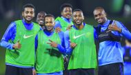 Almahdi Ali Mukhtar (left) and his Qatri team-mates gesture during a training session at Aspire zone in Doha.