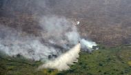A Super Puma helicopter operated by Asia Pulp and Paper drops water on a burning forest in Musi Banyuasin near Palembang, South Sumatra province, Indonesia, August 21, 2019. Antara Foto/Wahdi Septiawan/via Reuters