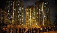Mourners queue along a road as they wait to pay their respects at the memorial service for Alex Chow, 22, who died last month from head injuries sustained during a fall inside a multi-storey carpark where police and protesters were clashing, at Po Fook Hi