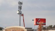 Several stores sits in front of a cell tower as workers rebuild a cellular tower with 5G equipment for the Verizon network on November 26, 2019 in Orem, Utah. George Frey / Getty Images / AFP