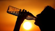 A woman drinks water during sunset as a heatwave hits France in Cagnicourt near Cambrai, France, June 25, 2019. Reuters / Pascal Rossignol